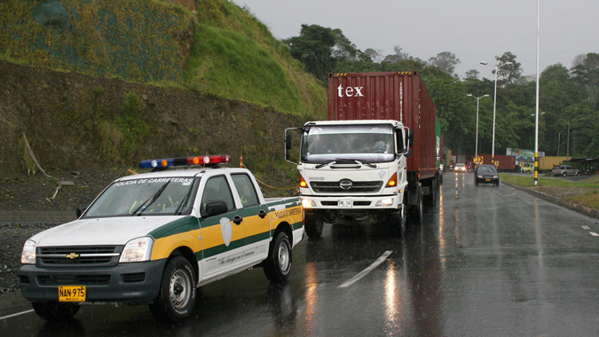 Foto de una carretera con camiones y policías